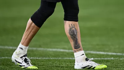 Soccer Football - UEFA Europa League - Quarter Final - First Leg - Bologna v Aston Villa - Stadio Renato Dall'Ara, Bologna, Italy - April 9, 2026 A tattoo of the world cup trophy on the leg of Aston Villa's Emiliano Martinez is seen during the warm up before the match REUTERS/Jennifer Lorenzini