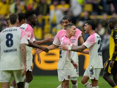 Leverkusen' players celebrate after winning the German Bundesliga soccer match between Borussia Dortmund and Bayer Leverkusen in Dortmund, Germany, Saturday, April 11, 2026. (AP Photo/Martin Meissner)