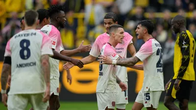 Leverkusen' players celebrate after winning the German Bundesliga soccer match between Borussia Dortmund and Bayer Leverkusen in Dortmund, Germany, Saturday, April 11, 2026. (AP Photo/Martin Meissner)