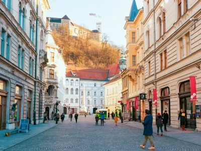 Ljubljana, Slovenia - January 15, 2019: Tourists on Stritarjeva Ulica Street and cityscape of Ljubljana old town with Castle, Slovenia, Europe. People in Slovenian city view in winter. Urban capital.