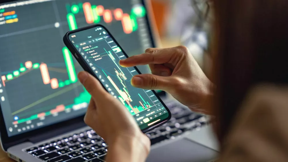Closeup - Woman is checking Bitcoin price chart on digital exchange on smartphone, cryptocurrency future price action prediction.