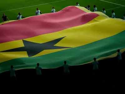 FILE - Volunteers lift the national flag of Ghana prior to the World Cup group H soccer match between Portugal and Ghana, at the Stadium 974 in Doha, Qatar, Thursday, Nov. 24, 2022. (AP Photo/Francisco Seco, File)