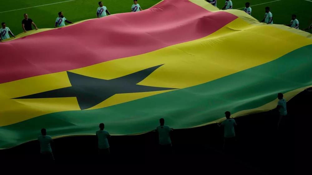FILE - Volunteers lift the national flag of Ghana prior to the World Cup group H soccer match between Portugal and Ghana, at the Stadium 974 in Doha, Qatar, Thursday, Nov. 24, 2022. (AP Photo/Francisco Seco, File)