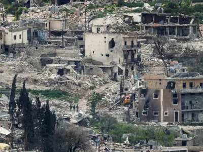 Israeli soldiers stand among destroyed buildings in southern Lebanon, near the Israel-Lebanon border, as seen from the Israeli side of the border in northern Israel, April 14, 2026. REUTERS/Florion Goga REFILE - QUALITY REPEAT