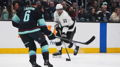 Los Angeles Kings center Anze Kopitar moves the puck against Seattle Kraken defenseman Adam Larsson (6) during the second period of an NHL hockey game Monday, April 13, 2026, in Seattle. (AP Photo/Lindsey Wasson)