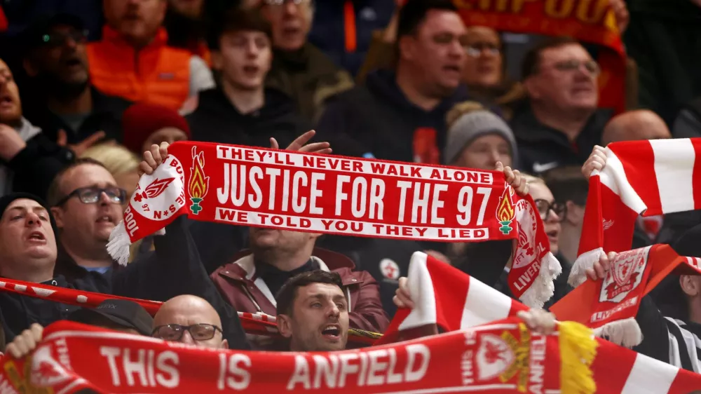 Soccer Football - UEFA Champions League - Quarter Final - Second Leg - Liverpool v Paris St Germain - Anfield, Liverpool, Britain - April 14, 2026 A Liverpool fan holds a scarf in memory of the 97 victims of the Hillsborough disaster inside the stadium before the match Action Images via Reuters/Lee Smith