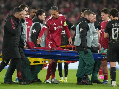 Liverpool's Virgil van Dijk checks on Hugo Ekitike during the Champions League quarterfinal second leg soccer match between Liverpool and Paris Saint-Germain in Liverpool, England, Tuesday, April 14, 2026. (AP Photo/Jon Super)