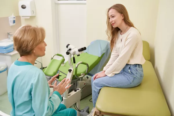Professional female doctor looking at her patient and discussing female disorders