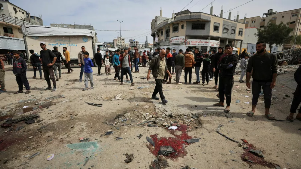 Palestinians gather to inspect the damage after an Israeli strike targeted a police vehicle in Gaza City, according to medics, in Gaza City, April 14, 2026. REUTERS/Dawoud Abu Alkas