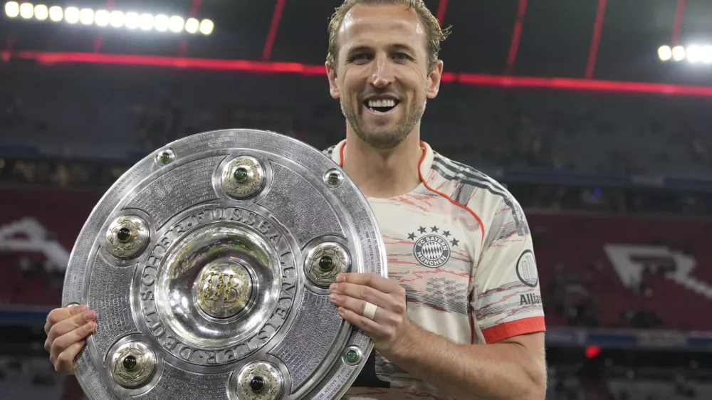 Bayern's Harry Kane poses with the championship shield after the German Bundesliga soccer match between FC Bayern Munich and Borussia Moenchengladbach in Munich, Germany, Saturday, May 10, 2025. (AP Photo/Matthias Schrader)
