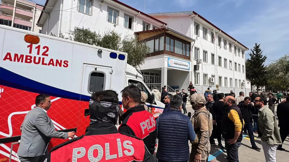 Turkish security forces and emergency staff stand in the courtyard of a secondary school where an assailant opened fire, in Kahramanmaras, Turkey, Wednesday, April 15, 2026, (IHA via AP)