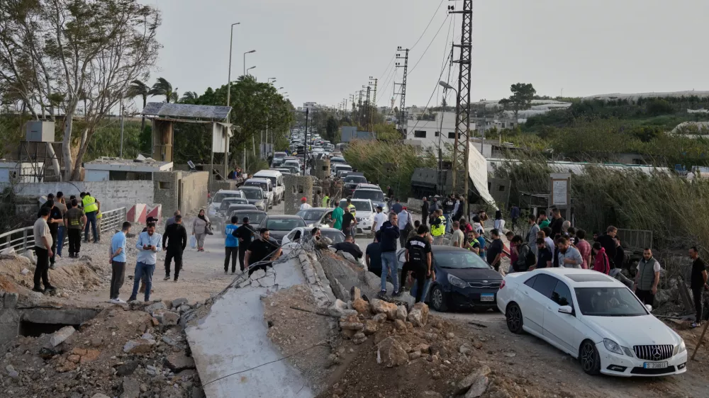 Displaced people returning to their villages following a ceasefire between Hezbollah and Israel, cross the destroyed Qasmiyeh bridge near Tyre city, south Lebanon, Friday, April 17, 2026. (AP Photo/Mohammed Zaatari)