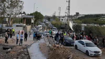 Displaced people returning to their villages following a ceasefire between Hezbollah and Israel, cross the destroyed Qasmiyeh bridge near Tyre city, south Lebanon, Friday, April 17, 2026. (AP Photo/Mohammed Zaatari)