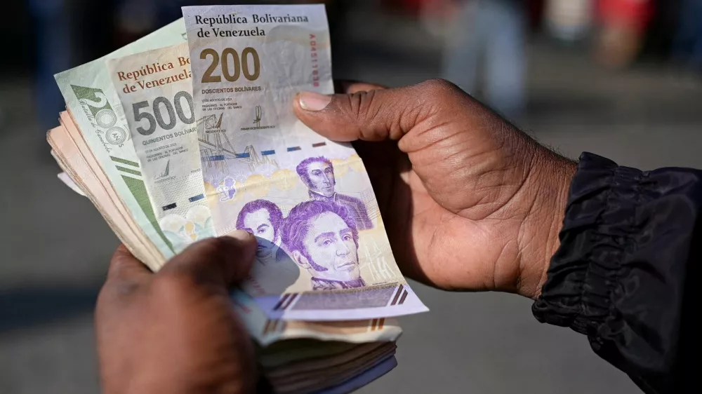 FILE PHOTO: A man shows the new 200 and 500 bolivar banknotes in Caracas, Venezuela September 3, 2024. REUTERS/Gaby Oraa/File Photo