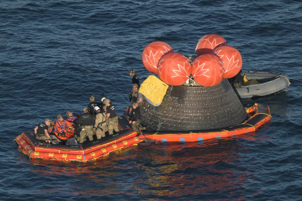 In this photo provided by NASA, Artemis II crew members Cmdr. Reid Wiseman, pilot Victor Glover, mission specialist Christina Koch and Canadian Space Agency mission specialist Jeremy Hansen are loaded into a raft after successfully splashing down in the Pacific Ocean on Friday, April 10, 2026, following their 10-day mission around the Moon. (James Blair/NASA via AP)