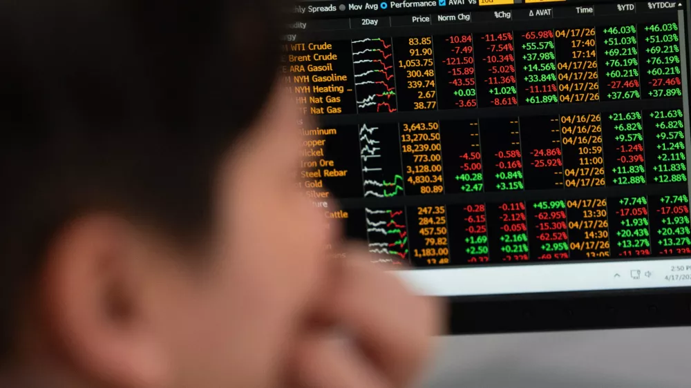 Global commodity prices including energy are displayed behind Portland State University guest teacher Khanh Anastasiou Vu in the finance lab on campus on Friday, April 17, 2026, in Portland, Ore. (AP Photo/Jenny Kane)