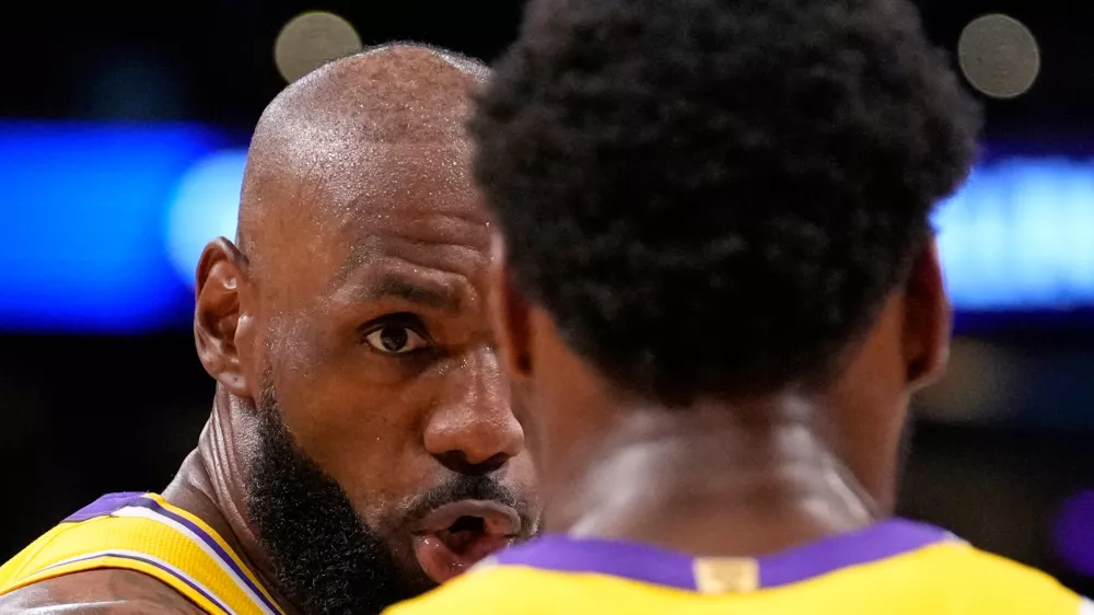 Los Angeles Lakers forward LeBron James, left, talks to guard Bronny James during the first half in Game 1 of a first-round NBA playoffs basketball series against the Houston Rockets, Saturday, April 18, 2026, in Los Angeles. (AP Photo/Mark J. Terrill)
