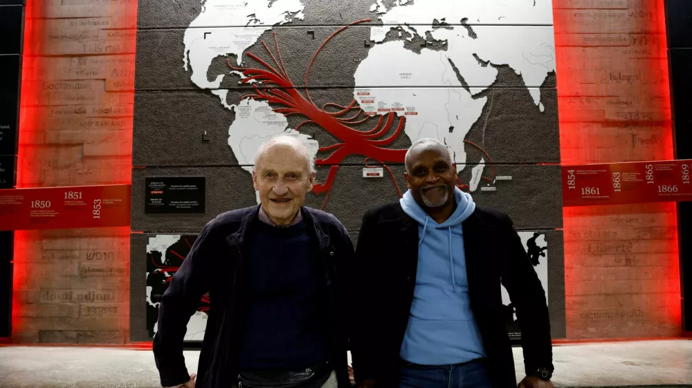 FILE PHOTO: Pierre Guillon de Prince, a 83-year-old descendant of a famous Nantes family whose ancestors were owners of ships transporting enslaved people, and Dieudonne Boutrin, a 59-year-old descendant of enslaved Africans in Martinique, president of the association La Coque Nomade-Fraternite, a human right association in Nantes which campaigns on slavery and reparations, pose at the Memorial to the Abolition of Slavery in Nantes, France, March 23, 2024. REUTERS/Stephane Mahe/File Photo