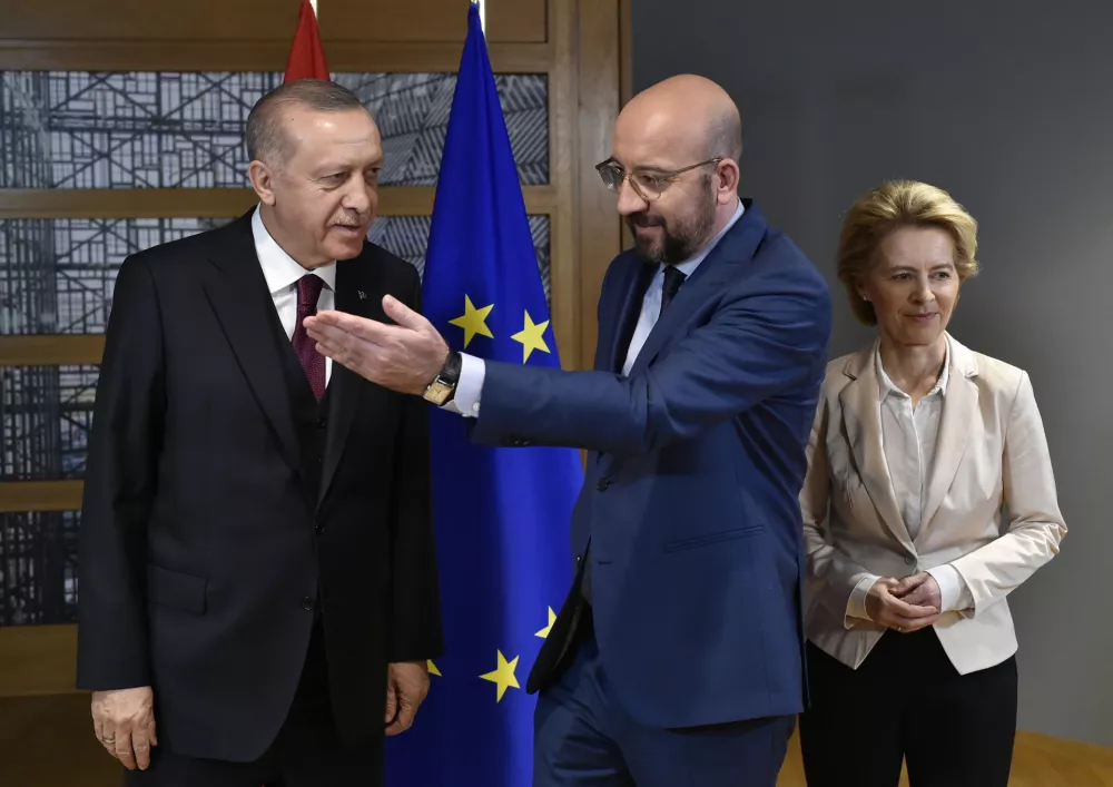 Turkish President Recep Tayyip Erdogan, left, is welcomed by European Council President Charles Michel, center, and European Commission President Ursula von der Leyen at the European Council building in Brussels, Monday, March 9, 2020. Turkish President Recep Tayyip Erdogan visits Brussels on Monday for talks with EU and NATO officials amid a standoff between Ankara and Brussels over sharing of responsibility for refugees and migrants. (John Thys, Pool Photo via AP)