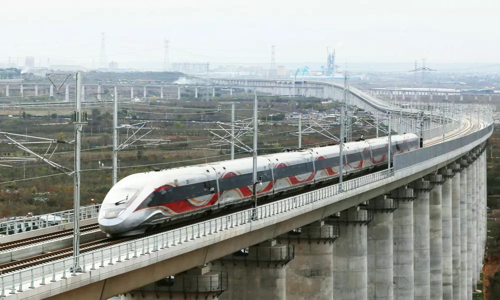 XI'AN, Nov. 17, 2025 -- A drone photo taken on Nov. 17, 2025 shows a test train running on a grand bridge of a high-speed railway line connecting Xi'an with Yan'an in northwest China's Shaanxi Province. A high-speed railway line connecting Xi'an, the capital of northwest China's Shaanxi Province, with Yan'an in northern Shaanxi has entered its trial operation phase, marking a significant step toward full operation. The trial run commenced on Monday morning when test train 55302 departed from Xi'an toward Yan'an -- transitioning from the joint debugging and testing phase to operational simulations. As the first high-speed railway in northern Shaanxi's old revolutionary base area, this 299.8-km project is designed for speeds of 350 km per hour and slashes the journey duration between Xi'an and Yan'an from 2.5 hours to approximately one hour. Yan'an holds profound historical significance -- as it served as the base of the Communist Party of China leadership between 1937 and 1947.,Image: 1052947556, License: Rights-managed, Restrictions:, Model Release: no