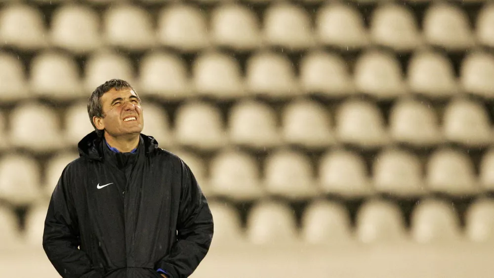 FILE PHOTO: Steaua Bucharest head coach Gheorghe Hagi looks at the sky as it rains during a practice session in Prague September 18, 2007. Steaua will play Slavia in a Champions League Group H soccer match on Wednesday in Prague. REUTERS/David W Cerny (CZECH REPUBLIC)/File Photo