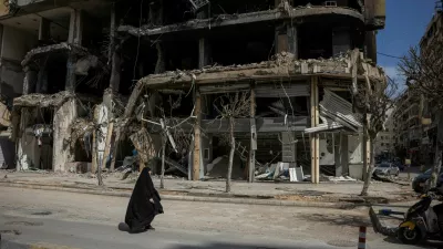 A woman walks past damaged buildings amid a 10-day ceasefire between Lebanon and Israel, in the southern suburbs of Beirut, Lebanon, April 20, 2026. REUTERS/Marko Djurica   TPX IMAGES OF THE DAY