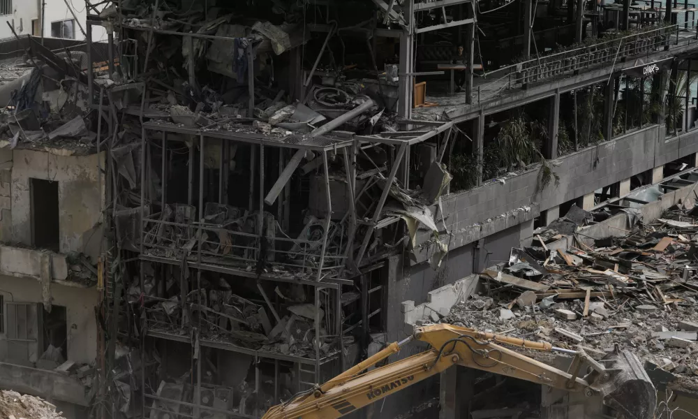 FILE - An excavator removes rubble from destroyed buildings that were hit by Israeli airstrikes on Thursday, as rescuers search for victims in the city of Tyre, southern Lebanon, Saturday, April 18, 2026. (AP Photo/Bilal Hussein, File)