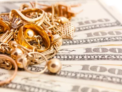 Closeup photo of jewelry on dollars. Isolated on white background. / Foto: Gerakl Getty Images/istockphoto