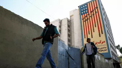 People walk past an anti-U.S. mural on a building, amid a ceasefire between U.S. and Iran, in Tehran, Iran, April 22, 2026. Majid Asgaripour/WANA (West Asia News Agency) via REUTERS ATTENTION EDITORS - THIS PICTURE WAS PROVIDED BY A THIRD PARTY
