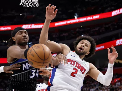 Orlando Magic center Wendell Carter Jr. (34) and Detroit Pistons guard Cade Cunningham (2) vie for the ball during the second half in Game 2 of a first-round NBA basketball playoffs series Wednesday, April 22, 2026, in Detroit. (AP Photo/Duane Burleson)