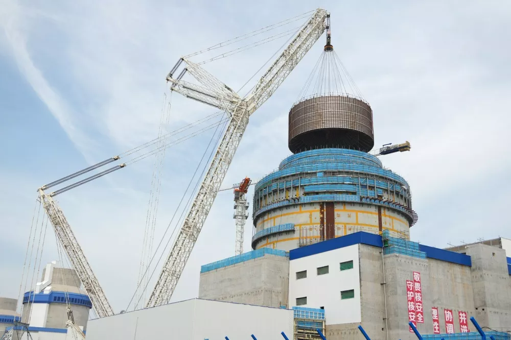 HAIYANG, Aug. 4, 2025 -- A crane lifts the CB20 module of the nuclear island for the 3rd unit of the Haiyang Nuclear Power Plant in Haiyang, east China's Shandong Province, Aug. 4, 2025. The CB20 module was successfully lifted and positioned on Monday, marking the completion of all major module installations for the 3rd unit of the Haiyang Nuclear Power Plant and the start of equipment installation and commissioning phase.,Image: 1027680909, License: Rights-managed, Restrictions:, Model Release: no