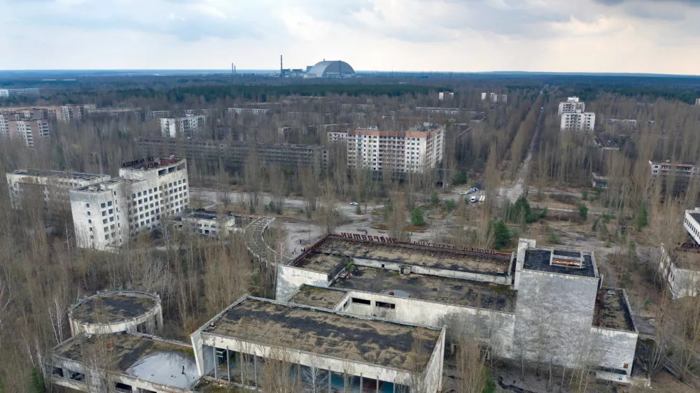 FILE - A dome-shaped shelter covering the damaged reactor at the Chernobyl nuclear plant is seen on the horizon, April 15, 2021, from the abandoned town of Pripyat, Ukraine, once home to some 50,000 people whose lives were connected to the plant. (AP Photo/Efrem Lukatsky, File)