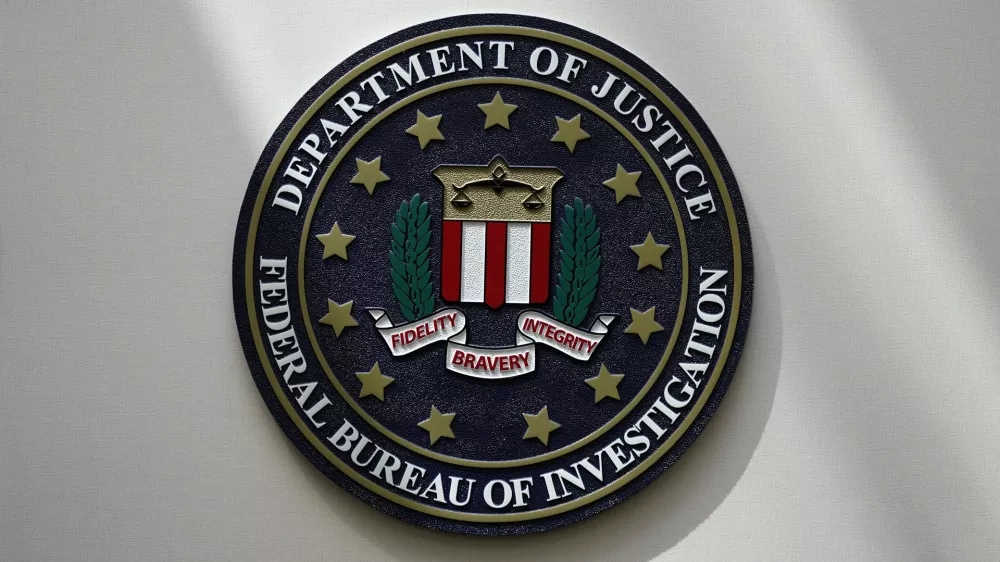 FILE - The FBI seal is pictured in Omaha, Neb., Aug. 10, 2022. A man who federal agents say tried to board a plane in New Jersey with three guns, including a semi-automatic rifle, and a fake law-enforcement ID is in federal custody and facing two charges. Seretse Clouden, who has a prior weapon-related conviction, is charged with possession of a firearm by a felon and having a fraudulent ID, according to a complaint posted Monday, Feb. 27, 2023. (AP Photo/Charlie Neibergall, File)