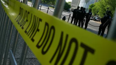 Police officers gather as people take part in a protest outside the Donald J. Trump Institute of Peace in Washington, D.C., U.S., April 23, 2026. REUTERS/Ken Cedeno