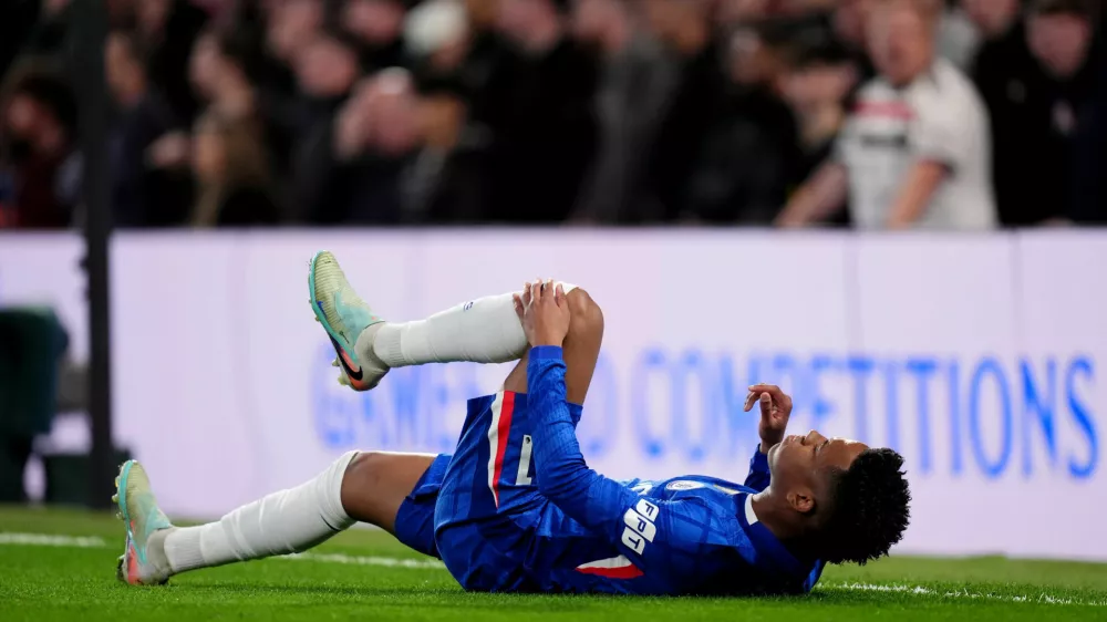 Chelsea's Estevao holds his leg after picking up an injury during the English Premier League soccer match in London, Saturday April 18, 2026. (John Walton/PA via AP)