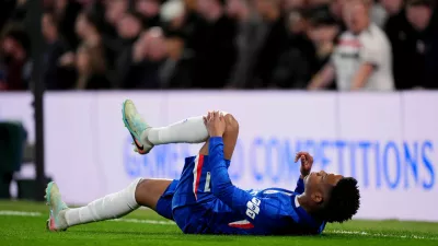 Chelsea's Estevao holds his leg after picking up an injury during the English Premier League soccer match in London, Saturday April 18, 2026. (John Walton/PA via AP)