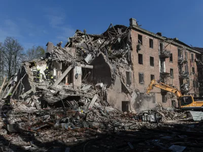 Rescue workers clear the rubble of a residential building destroyed by a Russian strike, in Dnipro, Ukraine, Saturday, April 25, 2026. (AP Photo/Mykola Synelnykov)
