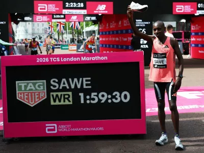 Athletics - London Marathon - London, Britain - April 26, 2026 Kenya's Sabastian Sawe celebrates with a shoe after winning the men's elite race and setting a new world record with a time of 01:59:30 REUTERS/Matthew Childs