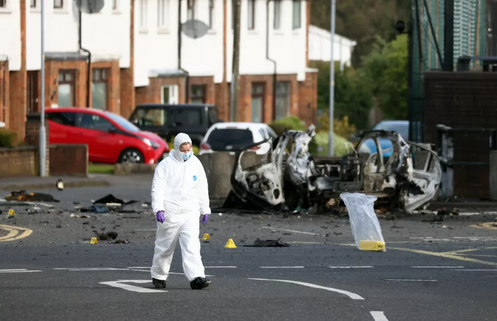 Forensic investigators inspect the site of a car bomb that exploded outside Dunmurry police station in South Belfast, Sunday, April 26, 2026. (AP Photo/Peter Morrison)