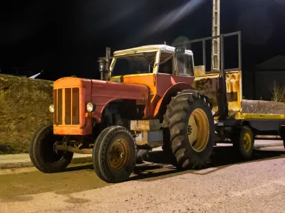 Night photograph of an old red tractor under artificial lighting.