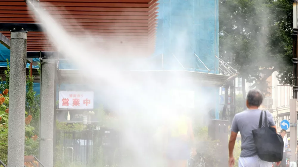 August 6, 2025, Tokyo, Japan - A pedestrian gets water mist shower to cool down at Tokyo's Ginza fashion district on Wednesday, August 6, 2025. Tokyo's temperature climbed to 37 degree Celsius on August 6 while Tokyo's suburban Isesaki city in Gunma prefecture marked Japan's record-high of 41.8 degree Celsius on August 5.,Image: 1028198254, License: Rights-managed, Restrictions: No third party sales, Model Release: no