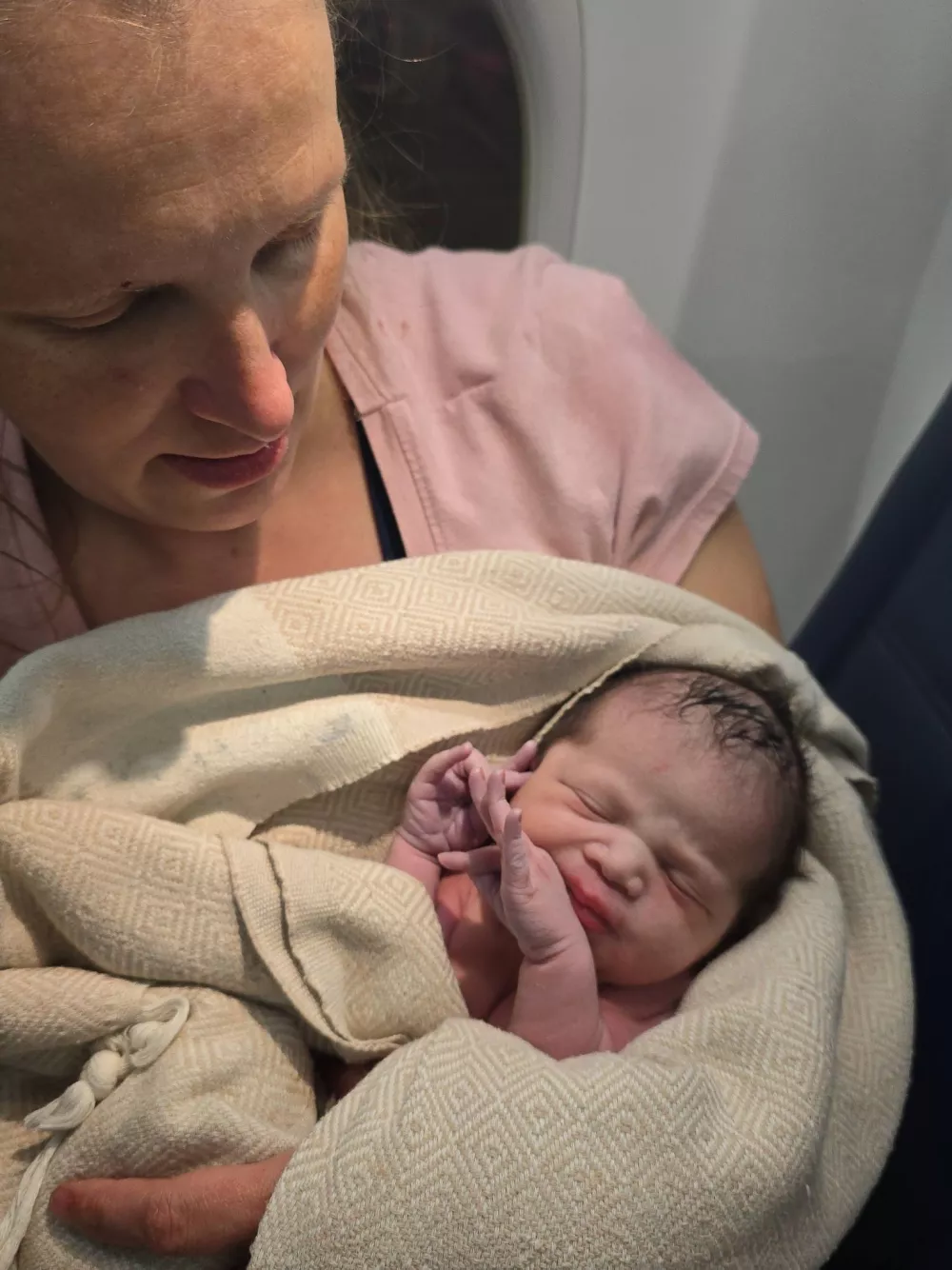In this photo provided by Tina Fritz, Ashley Blair holds her daughter Brielle, who was born April 24, 2026, on a Delta Air Lines flight just as it was landing in Portland, Ore. (Photo by Tina Fritz via AP)