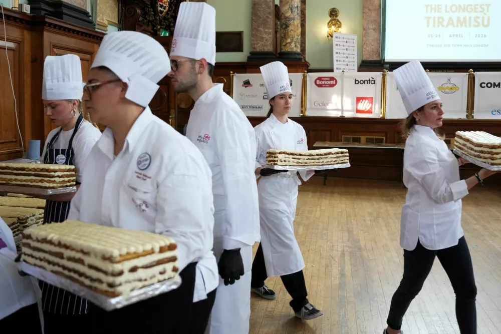 Chefs and volunteers carry parts of a tiramisu during preparations for their attempt to break the Guinness World Record for the longest tiramisu, with the dessert expected to exceed 300 metres, in London, Britain, April 26, 2026. REUTERS/Carlos Jasso