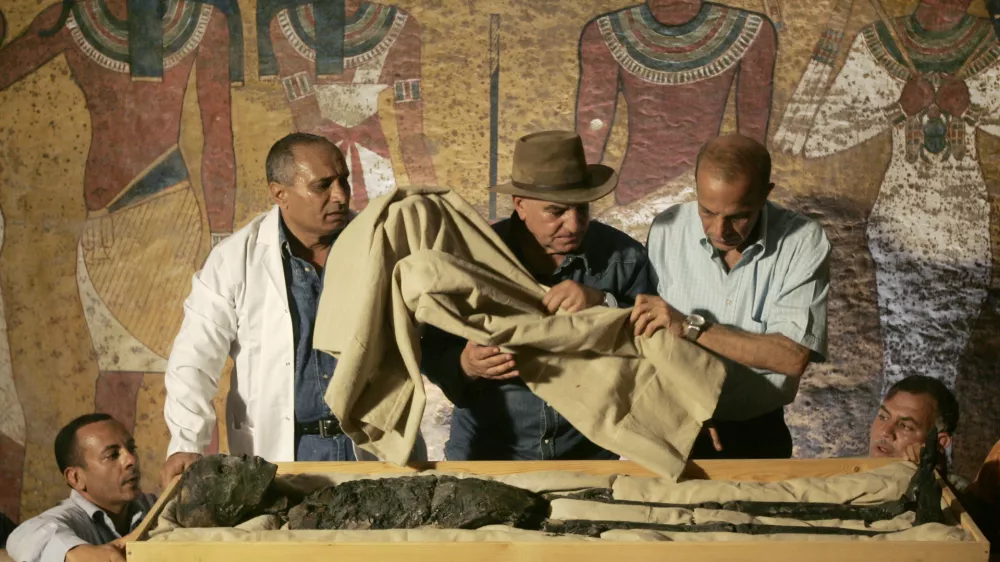 FILE - In this Nov. 4, 2007 file photo, Egypt's antiquities chief Dr. Zahi Hawass, center, supervises the removal of the mummy of King Tutankhamun from his stone sarcophagus in his underground tomb in the famed Valley of the Kings in Luxor, Egypt. Egypt's famed King Tutankhamun suffered from a cleft palate and club foot, likely forcing him to walk with a cane, and died from complications from a broken leg exacerbated by malaria, according to the most extensive study ever of his mummy. (AP Photo/Ben Curtis, Pool, File) / Foto: Ben Curtis