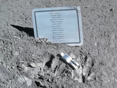 Spominsko obeležje in skulptura Padli astronavt, postavljena na Luni med misijo Apollo 15 leta 1971. Imena: Theodore C. Freeman, Charles A. Bassett II, Elliot M. See Jr., Virgil I. Grissom, Roger B. Chaffee, Edward H. White II, Vladimir M. Komarov, Edward G. Givens Jr., Clifton C. Williams Jr., Jurij A. Gagarin, Pavel I. Beljajev, Georgij T. Dobrovoljski, Viktor I. Pacajev, Vladislav N. Volkov. / Foto: Nasa