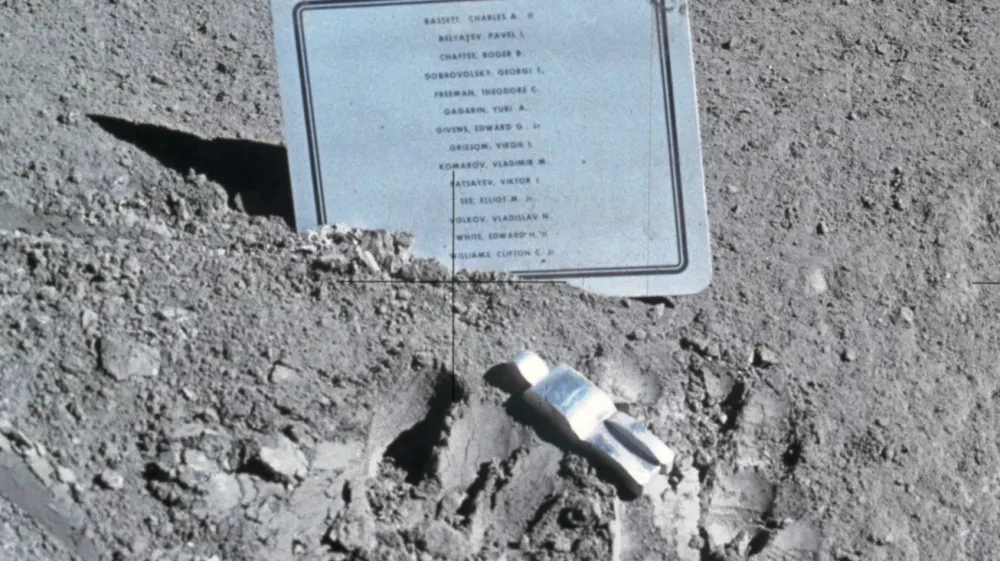 Spominsko obeležje in skulptura Padli astronavt, postavljena na Luni med misijo Apollo 15 leta 1971. Imena: Theodore C. Freeman, Charles A. Bassett II, Elliot M. See Jr., Virgil I. Grissom, Roger B. Chaffee, Edward H. White II, Vladimir M. Komarov, Edward G. Givens Jr., Clifton C. Williams Jr., Jurij A. Gagarin, Pavel I. Beljajev, Georgij T. Dobrovoljski, Viktor I. Pacajev, Vladislav N. Volkov. / Foto: Nasa