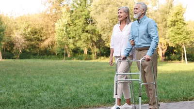 Senior couple with walking frame in park, space for text / Foto: Olga Yastremska