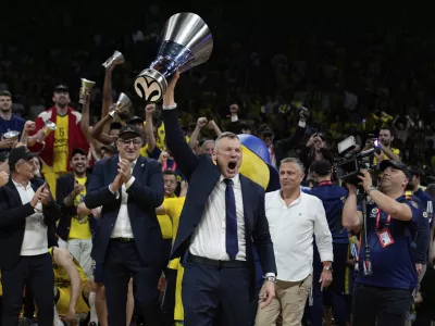 Fenerbahce's head coach Saras Jasikevicius holds the trophy as they celebrate winning the Euroleague final basketball match between Monaco and Fenerbahce in Abu Dhabi, United Arab Emirates, Sunday, May 25, 2025. (AP Photo/Altaf Qadri)