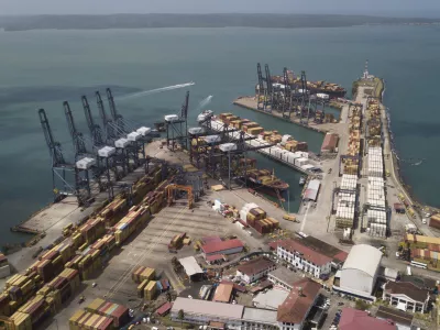 Cargo containers sit stacked as cranes load and unload containers from cargo ships at the Cristobal port, operated by the Panama Ports Company, in Colon, Tuesday, Panama, Feb. 4, 2025. (AP Photo/Matias Delacroix)