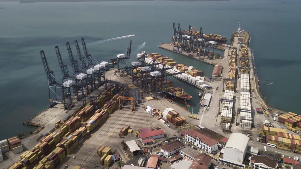 Cargo containers sit stacked as cranes load and unload containers from cargo ships at the Cristobal port, operated by the Panama Ports Company, in Colon, Tuesday, Panama, Feb. 4, 2025. (AP Photo/Matias Delacroix)